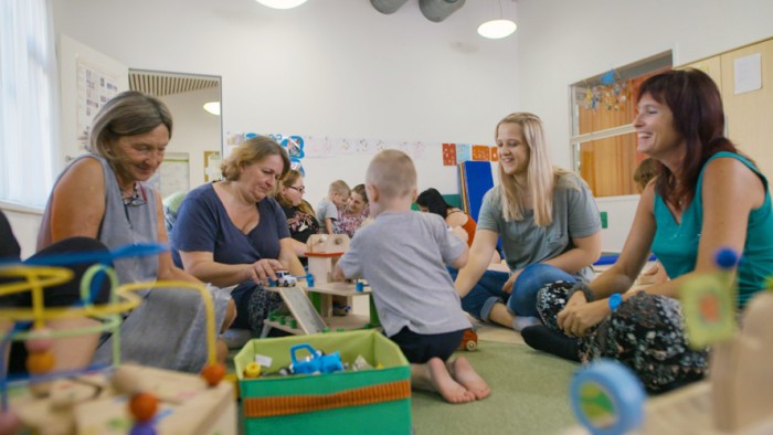 Kleinkinder spielen mit ihren Müttern auf dem Boden