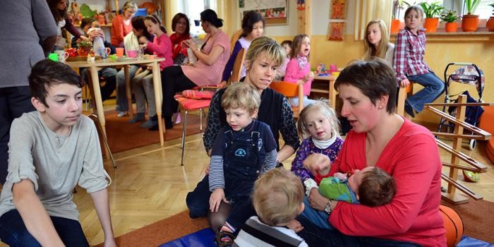 Spielende Kinder und Betreuerinnen im Familientreff