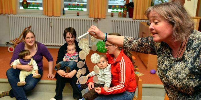 Spielende Kinder und Betreuerinnen im Familientreff