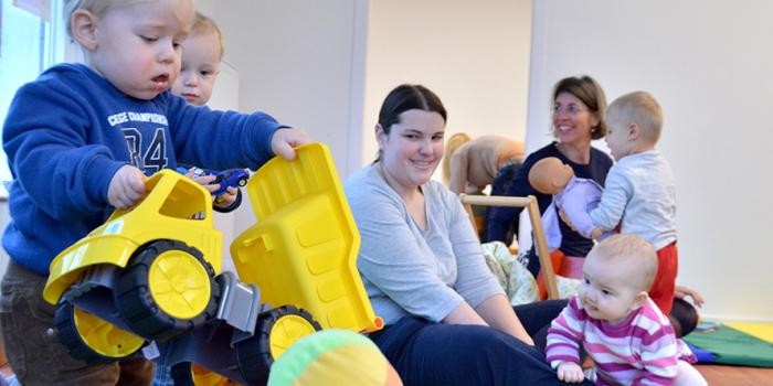 Spielende Kinder und Betreuerinnen im Familientreff