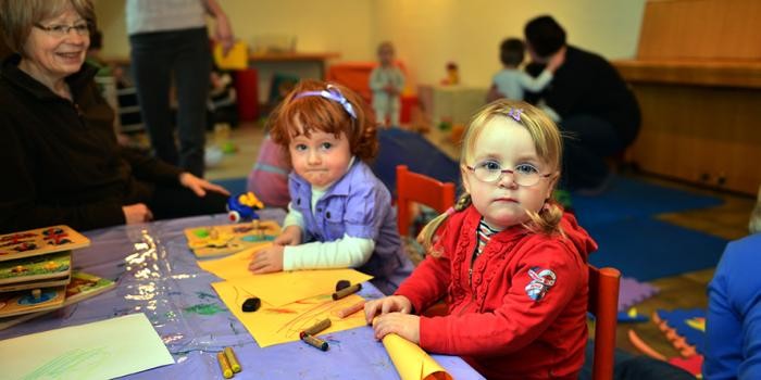 Spielende Kinder und Betreuerinnen im Familientreff